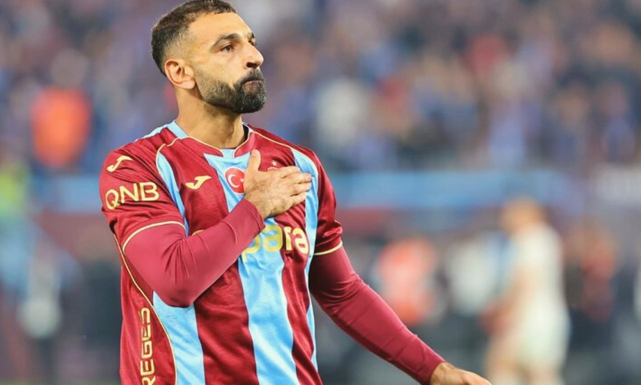 Gece maçında stadyum ışıkları altında duran futbol topu ve çim saha.