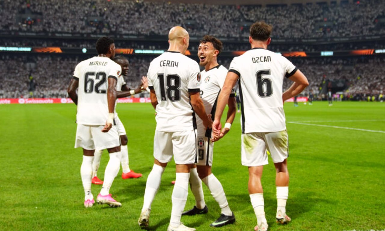 Gece ışıklandırılmış modern bir futbol stadyumu ve çim saha