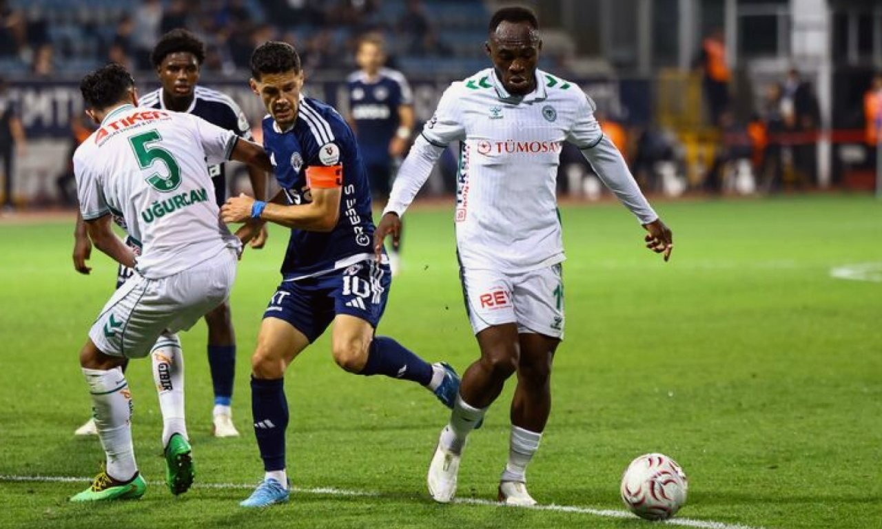 Gece aydınlatması altında boş futbol sahası ve stadyum tribünleri.